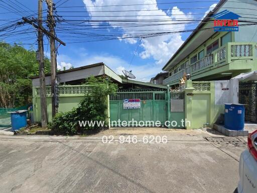 Front view of a residential property with gate and surrounding wall