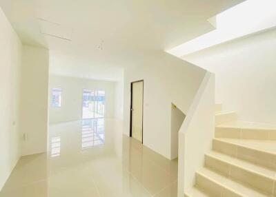 Bright main living space with stairs and large windows