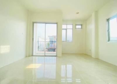 Bright and spacious empty living room with large windows and a balcony