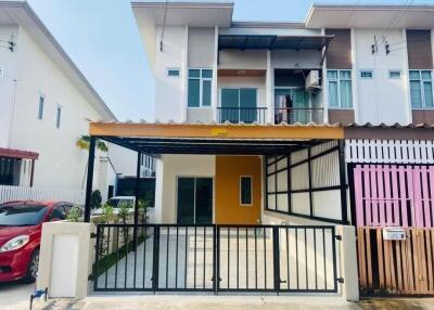 Front of a modern townhouse with a carport and gate