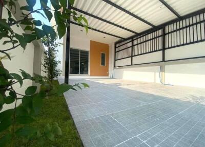 Covered outdoor patio with tiled floor and garden