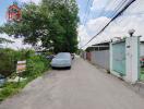 Street view with cars and a 'For Sale' sign