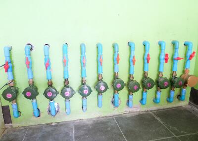 Water valves and piping on green wall