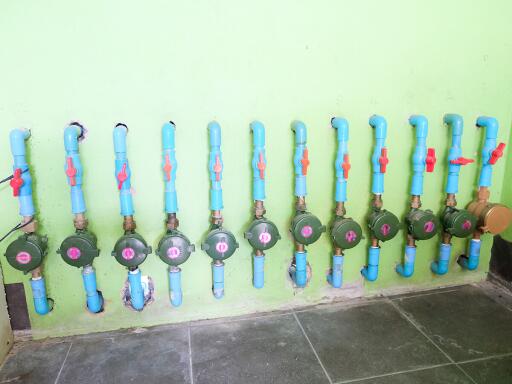 Water valves and piping on green wall