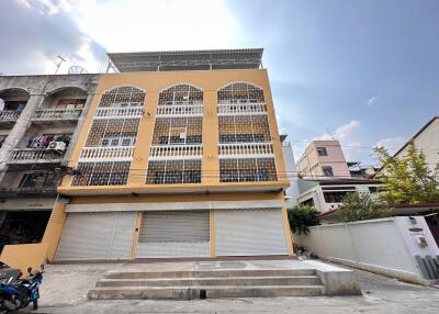 Front view of a multi-story building with yellow facade