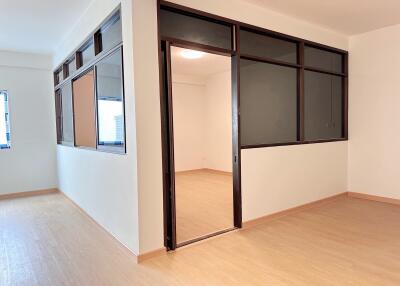 Empty room with large windows and wooden flooring