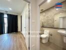 View of a bathroom and an adjacent room with wooden flooring