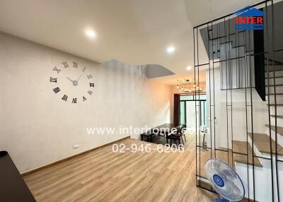 Modern living room with wooden flooring and a wall clock