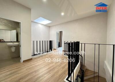 Spacious hallway with wooden flooring and modern railing