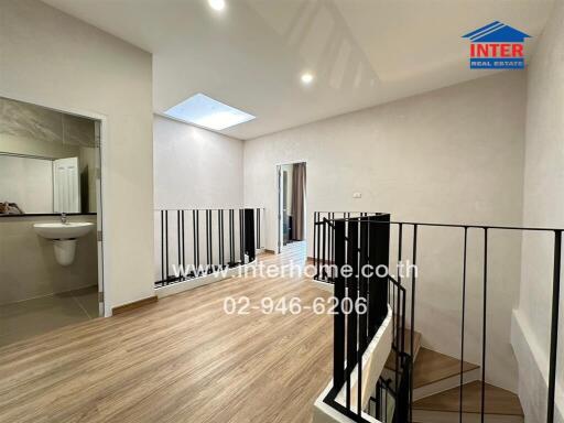 Spacious hallway with wooden flooring and modern railing