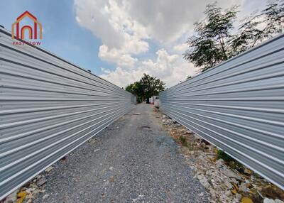 Narrow outdoor pathway with metal fencing