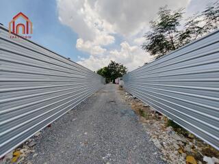 Narrow outdoor pathway with metal fencing