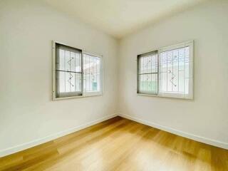 Empty bedroom with wooden floor and barred windows