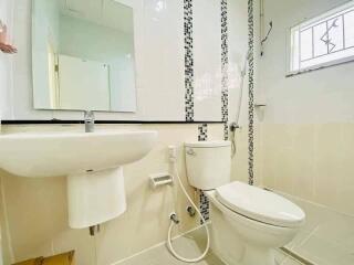 Modern bathroom with white fixtures and decorative tile accents