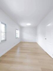 Spacious empty room with large windows and wooden flooring