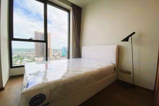 Modern bedroom with a large window and city view