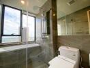 Modern bathroom with large window and city view