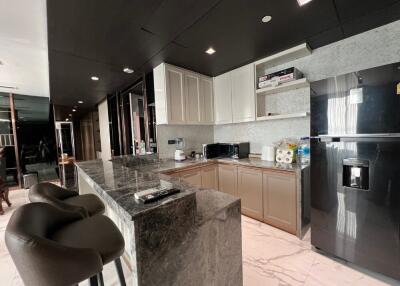 Modern kitchen with marble countertops and dark cabinetry