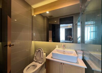 Modern bathroom with toilet, sink, and mirror