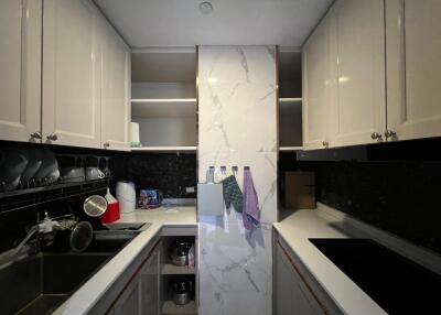 Compact modern kitchen with white cabinets and marble backsplash