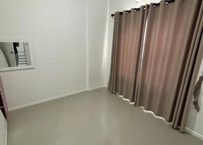 Empty bedroom with curtains and mounted air conditioner