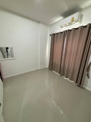 Empty bedroom with curtains and mounted air conditioner