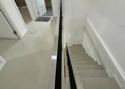 Modern staircase leading to a hallway with bathroom