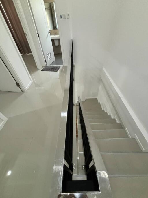 Modern staircase leading to a hallway with bathroom