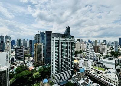 Aerial view of city with modern high-rise buildings under a partly cloudy sky