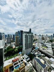 Aerial view of city with modern high-rise buildings under a partly cloudy sky