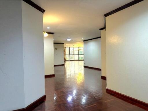 Main living area with hardwood floors, crown molding, and ample natural light