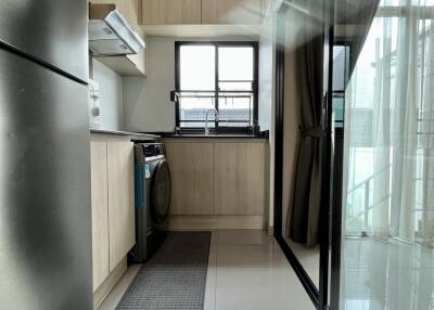 Modern kitchen with stainless steel refrigerator, washing machine, and large window