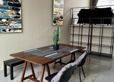 Modern dining area with table and chairs, artwork, and indoor plant