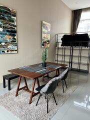 Modern dining area with table and chairs, artwork, and indoor plant