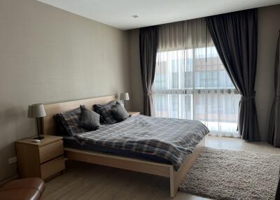 Modern bedroom with large window, double bed, and neutral decor