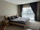 Modern bedroom with large window, double bed, and neutral decor