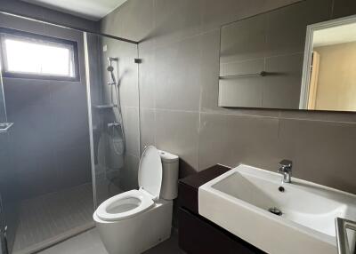 Modern bathroom with large sink, toilet, and shower