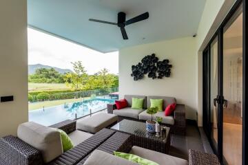 Outdoor living space with a view of the pool and greenery