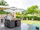 Outdoor patio area with dining table and barbecue grill