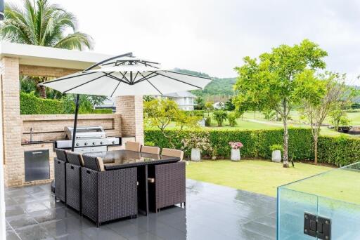 Outdoor patio area with dining table and barbecue grill