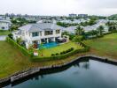 Aerial view of a modern house with a swimming pool and a lake