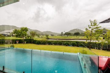 view of a swimming pool and golf course from the house