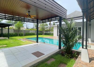 Covered patio area with a pool and garden