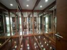 Spacious walk-in closet with full-length mirrors and wooden flooring