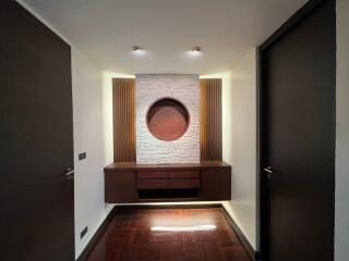 Modern hallway with built-in wooden cabinet and decorative stone accent wall