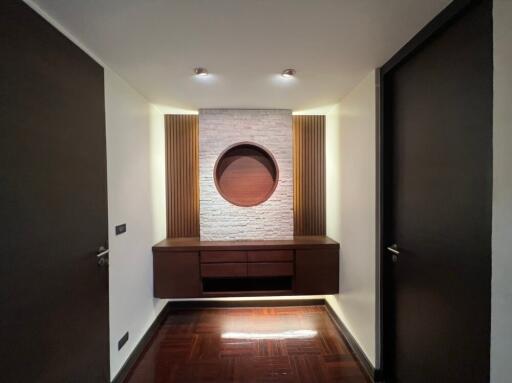 Modern hallway with built-in wooden cabinet and decorative stone accent wall