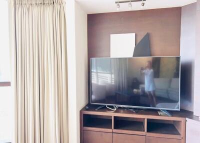 Living room with large flat-screen TV and wooden entertainment unit