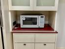 Kitchen area with microwave and storage cabinets