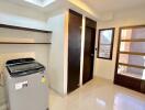 Bright laundry room with washing machine and shelves