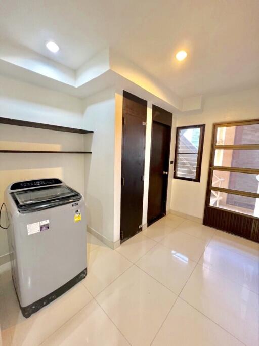 Bright laundry room with washing machine and shelves